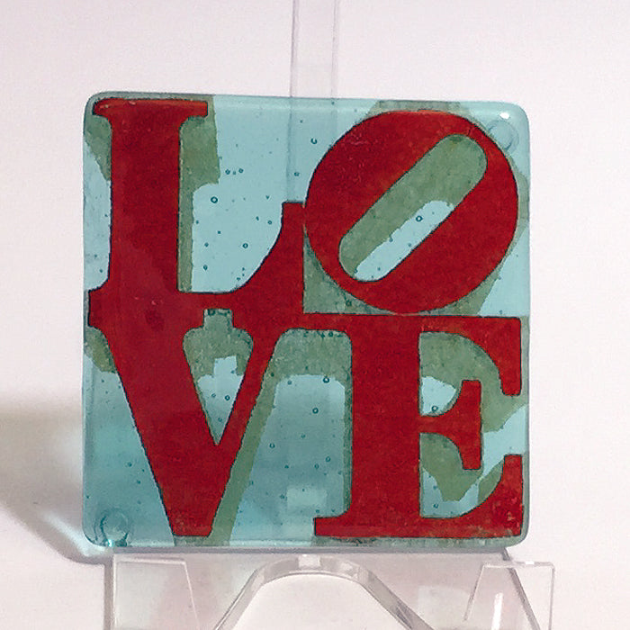 a glass sign with the word love painted on it