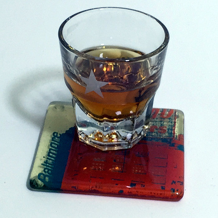 a glass of alcohol sitting on top of a coaster