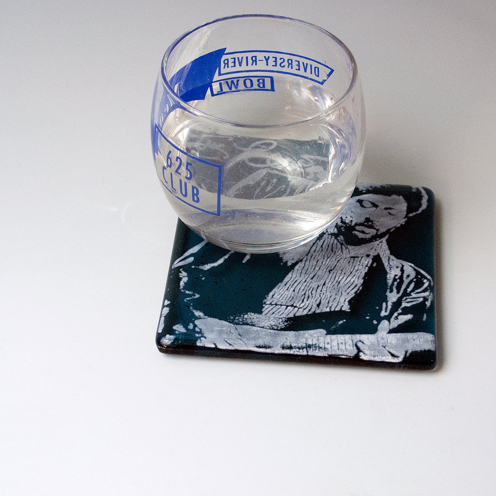 a glass of water sitting on top of a coaster