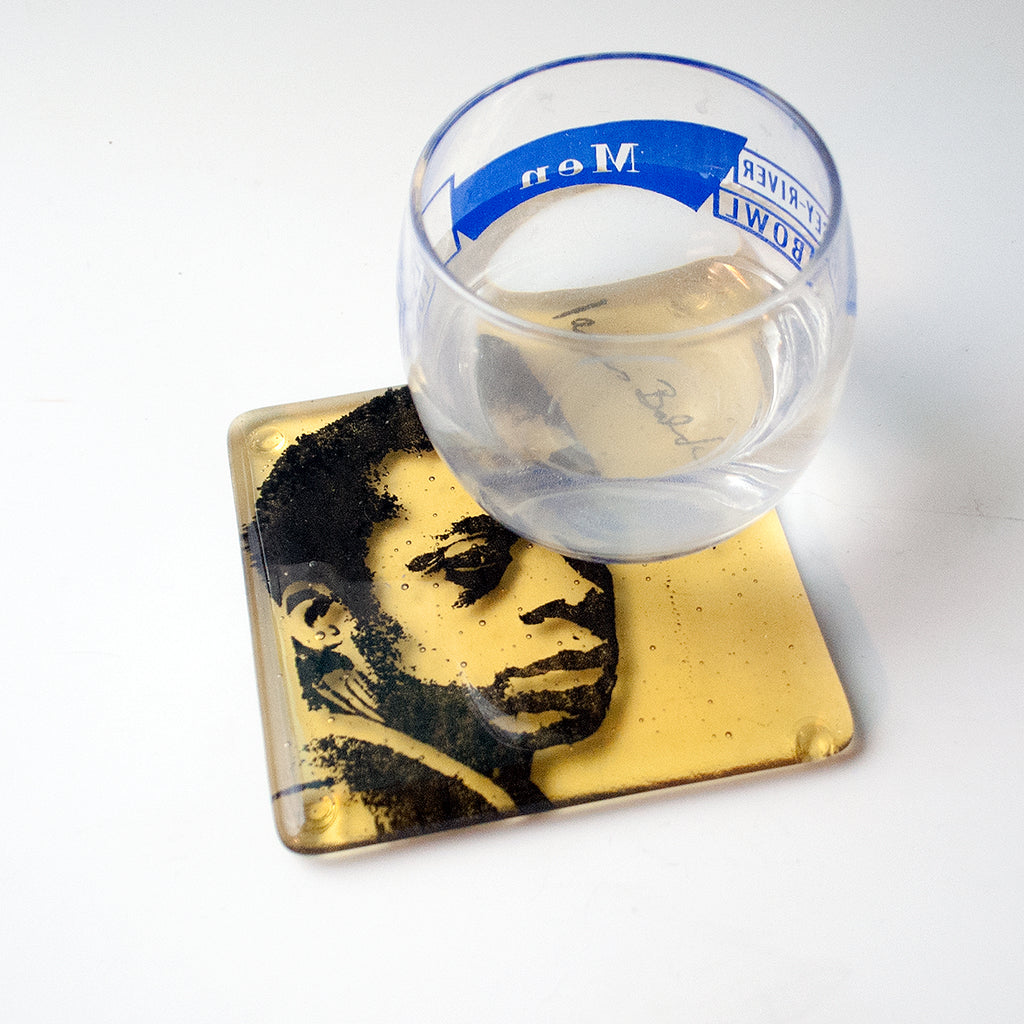 a glass of water sitting on top of a coaster