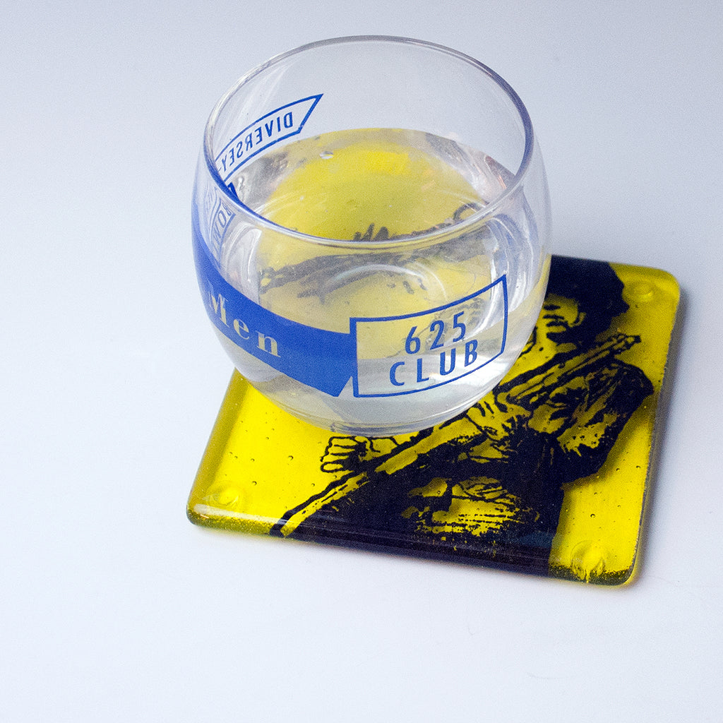 a glass of water sitting on top of a coaster