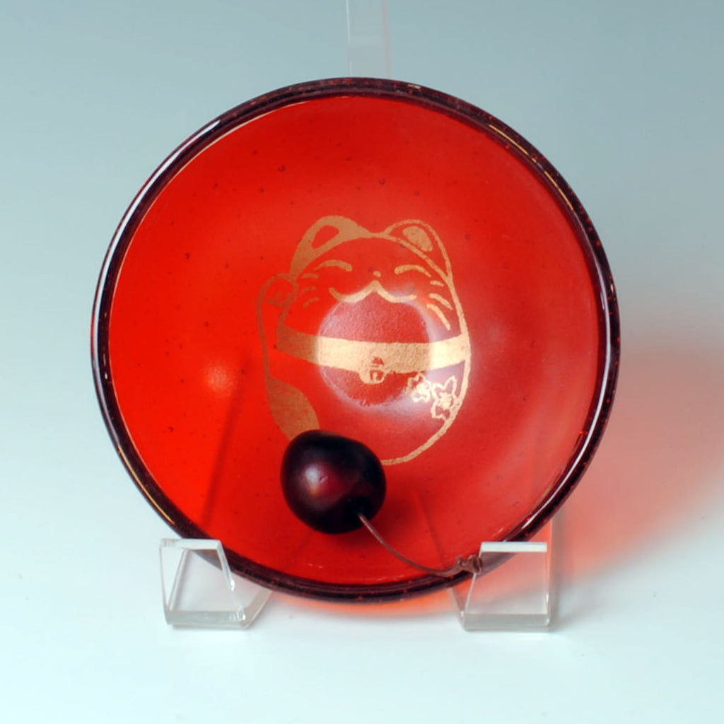 a red bowl with a gold design on it