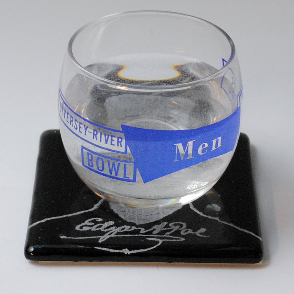 a glass of water sitting on top of a coaster