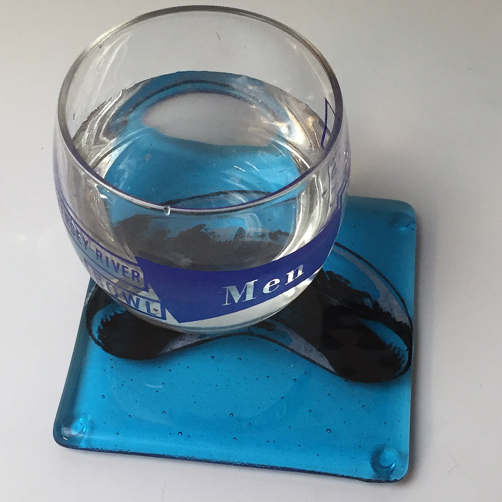 a glass of water sitting on top of a blue coaster