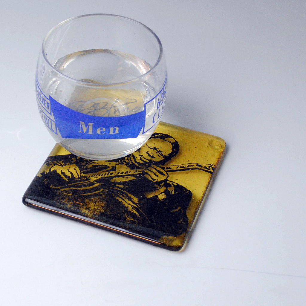 a glass of water sitting on top of a coaster