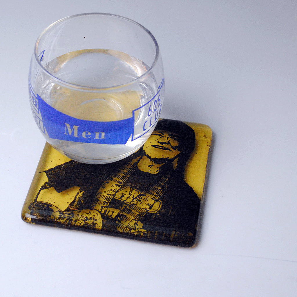 a glass of water sitting on top of a coaster