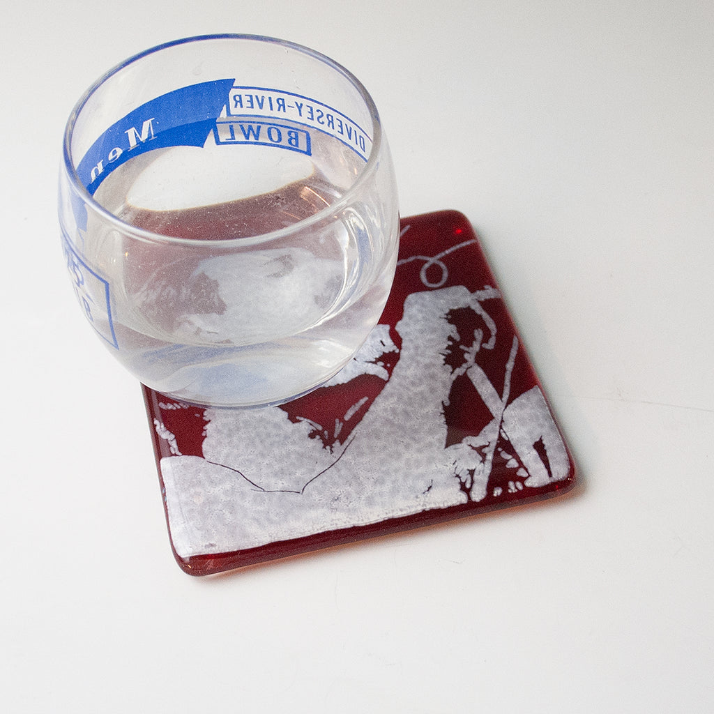 a glass of water sitting on top of a coaster