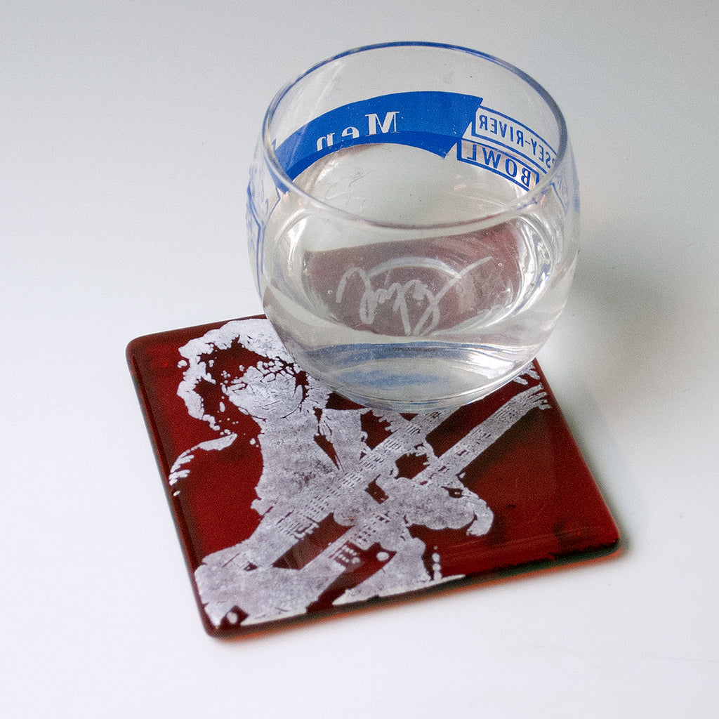 a glass of water sitting on top of a red coaster