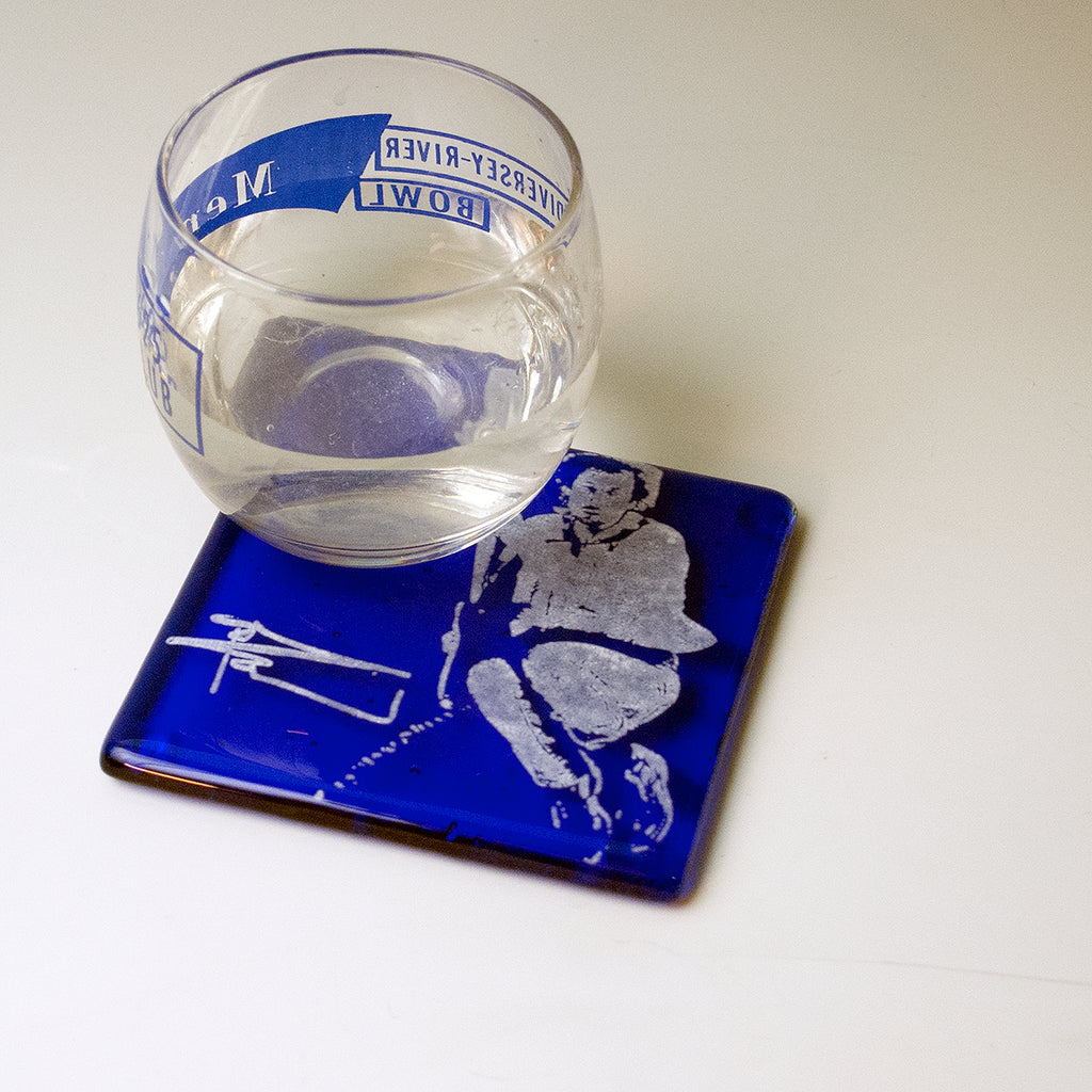 a glass of water sitting on top of a blue coaster