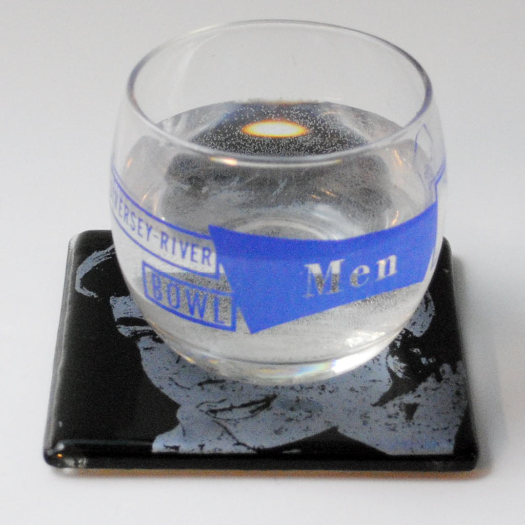 a glass of water sitting on top of a coaster