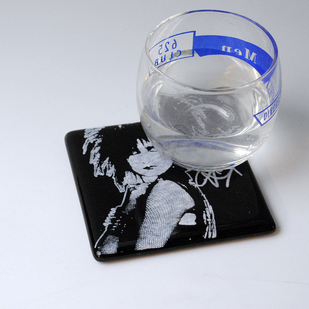 a glass of water sitting on top of a coaster