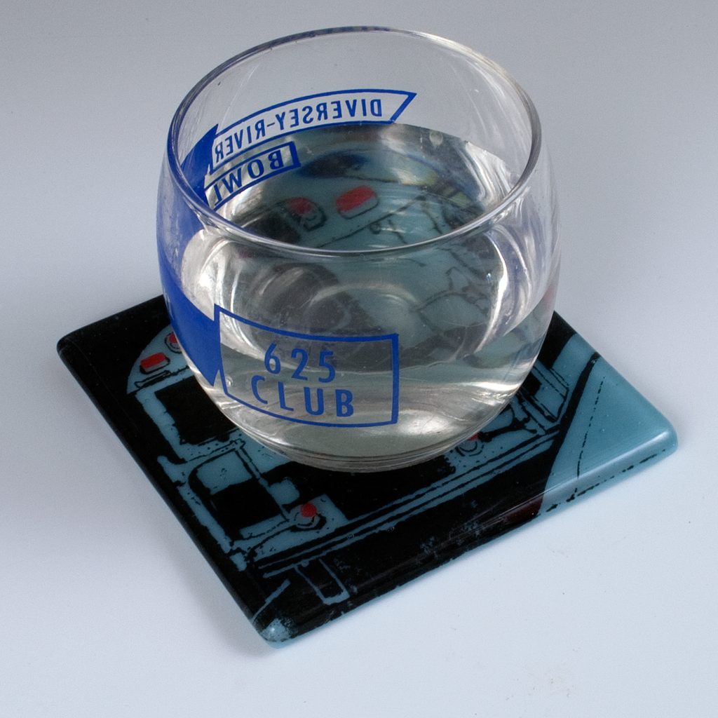 a glass of water sitting on top of a coaster