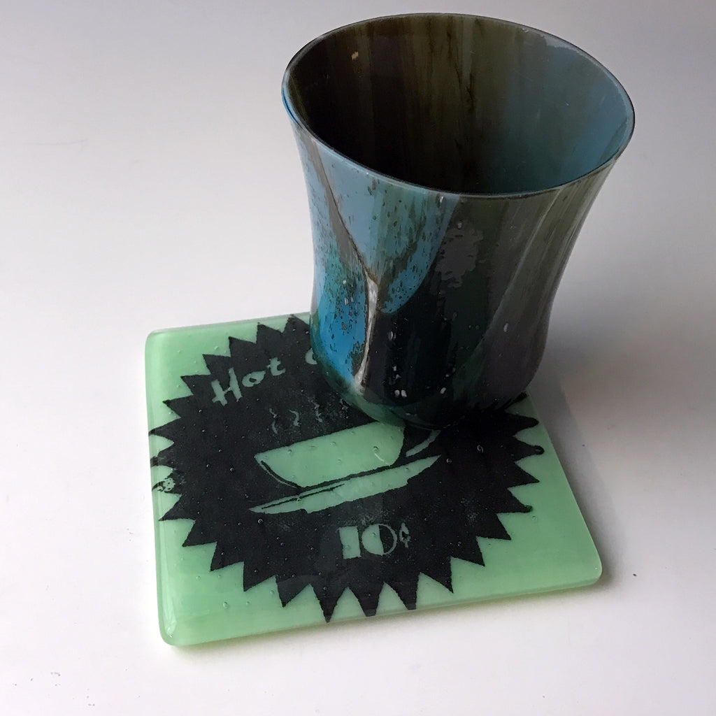 a cup sitting on top of a coaster on a table