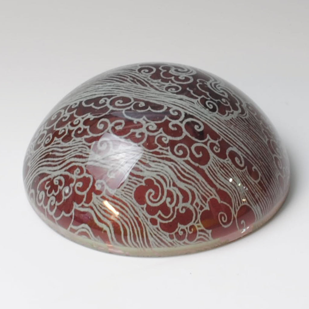 a red and white vase sitting on top of a white table