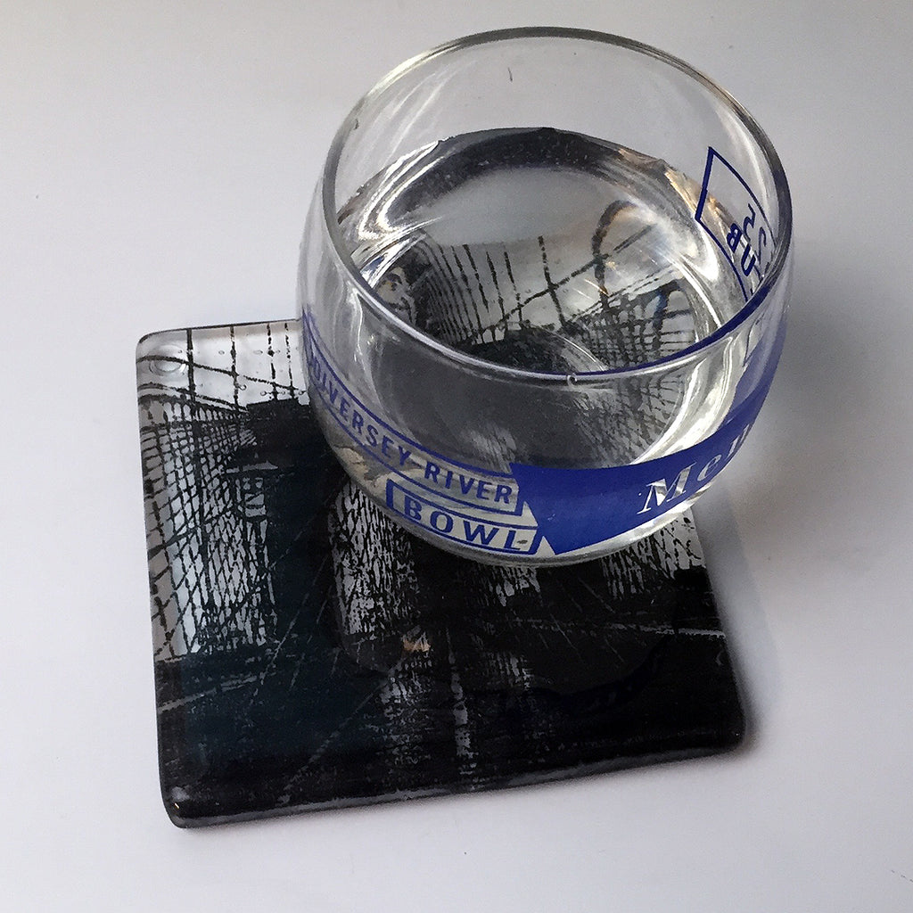 a glass of water sitting on top of a coaster