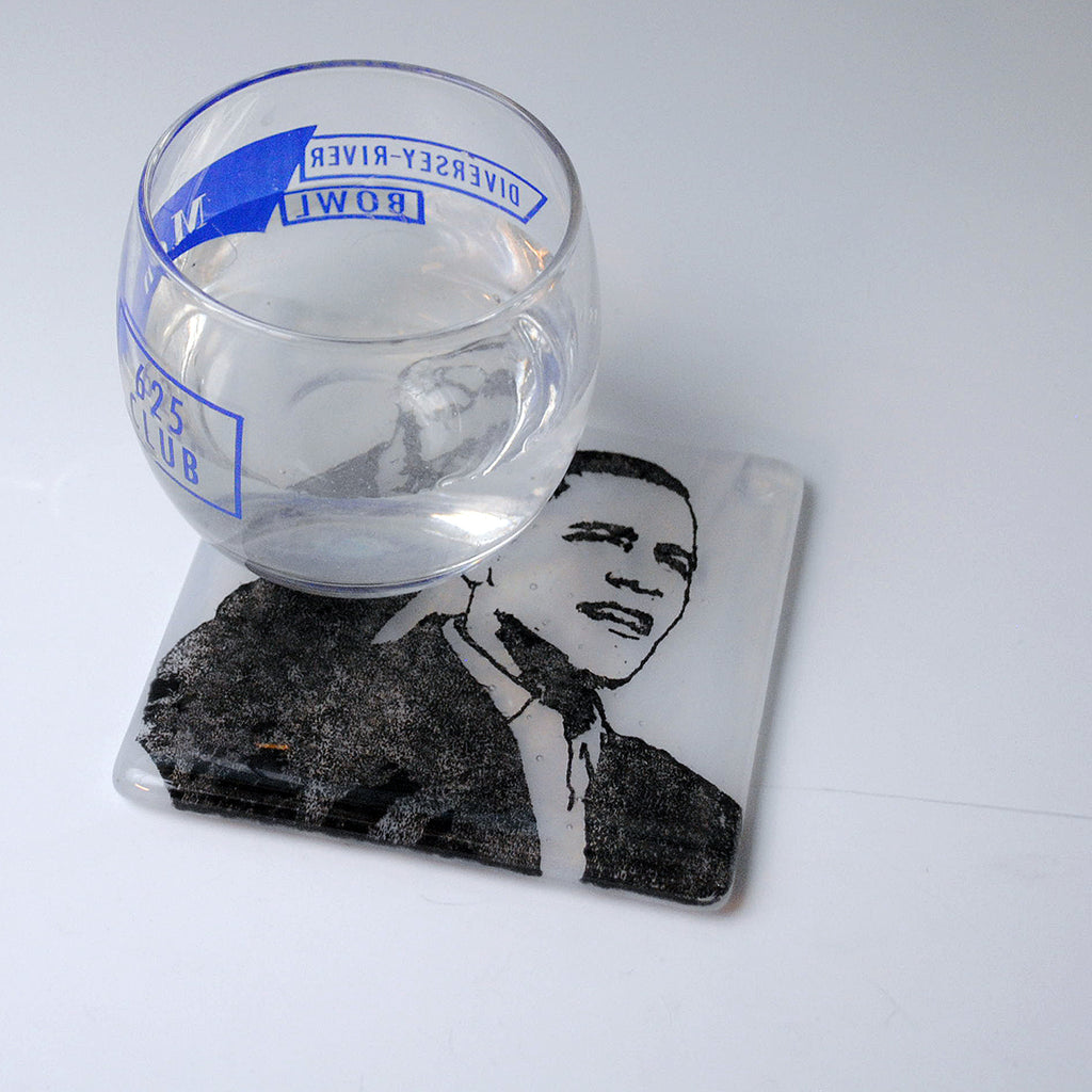 a glass of water sitting on top of a coaster