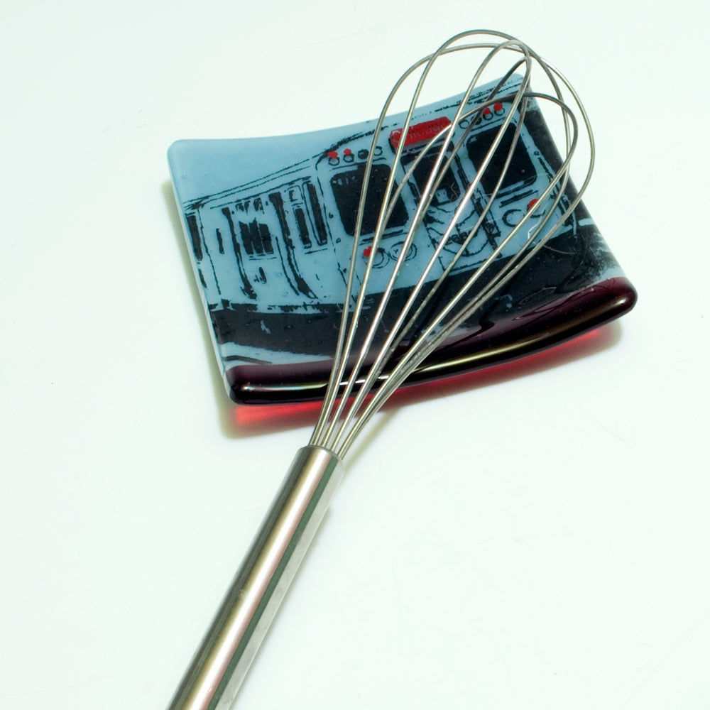 a metal whisk sitting on top of a white table