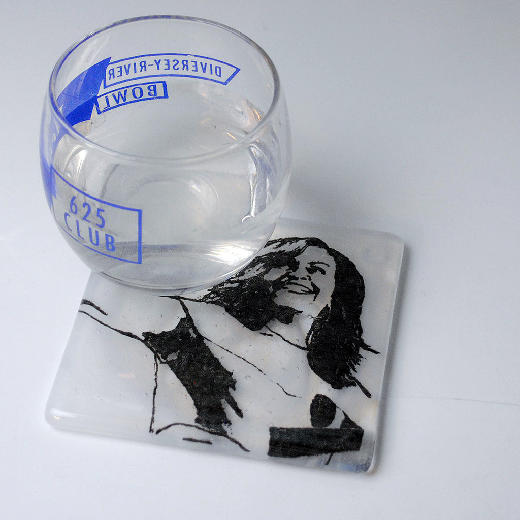 a glass of water sitting on top of a coaster