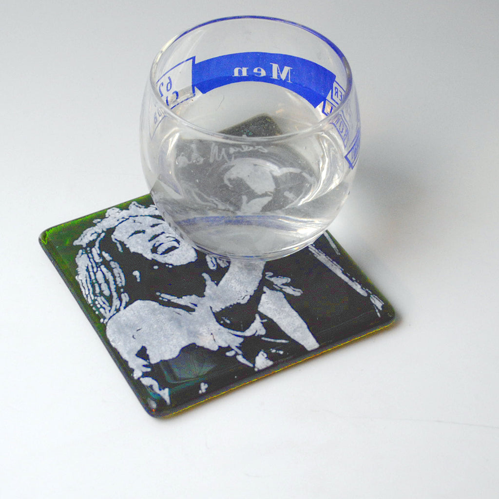 a glass of water sitting on top of a coaster