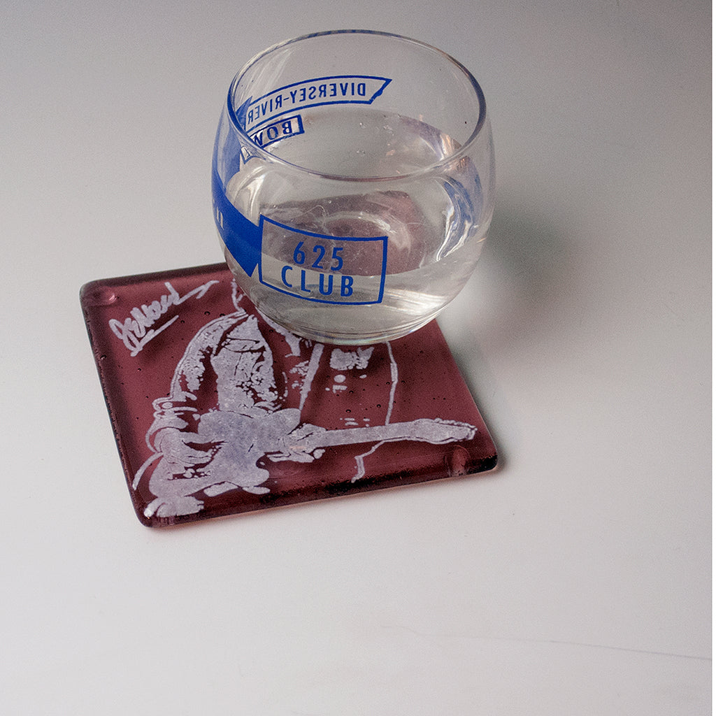 a glass of water sitting on top of a coaster