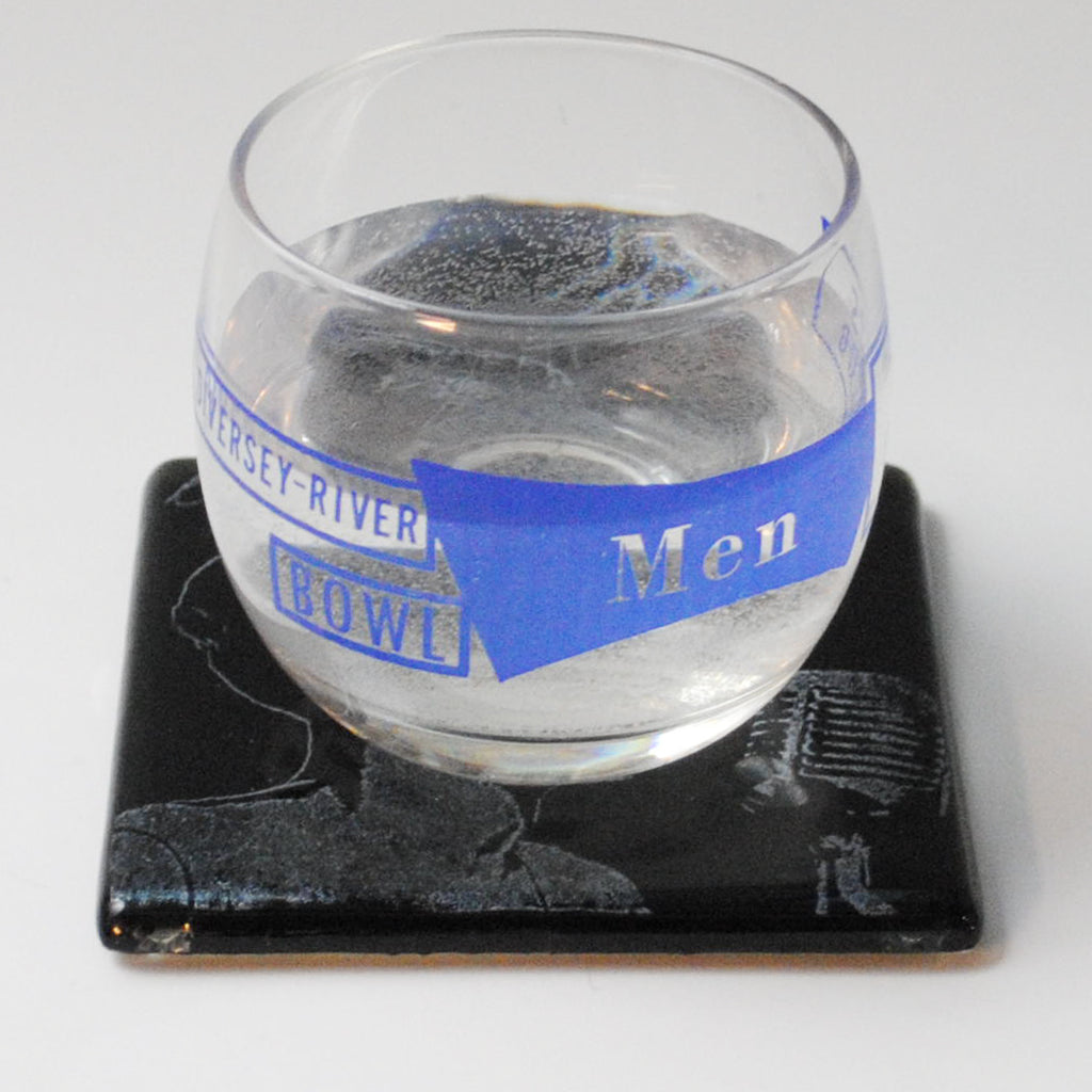 a glass of water sitting on top of a coaster