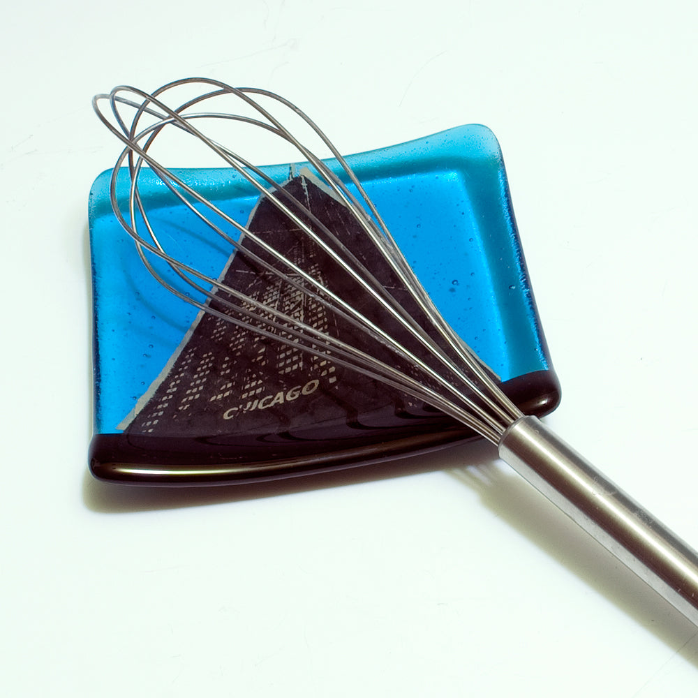 a close up of a whisk on a blue plate