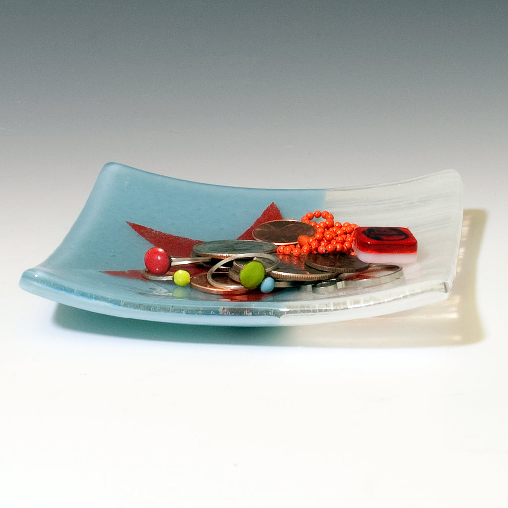 a glass plate with scissors and beads on it