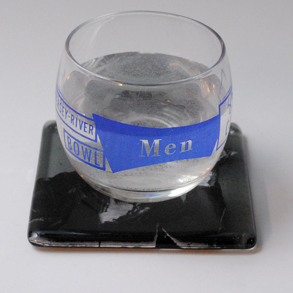 a glass of water sitting on top of a coaster