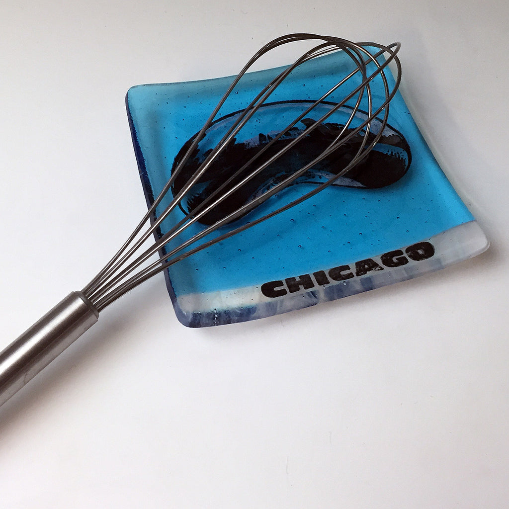 a whisk is sitting on top of a blue plate