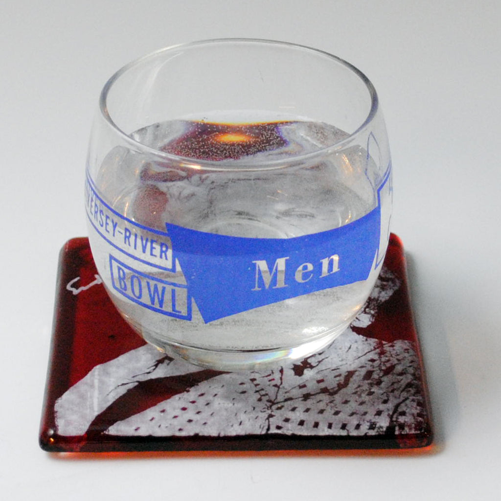 a glass of water sitting on top of a coaster