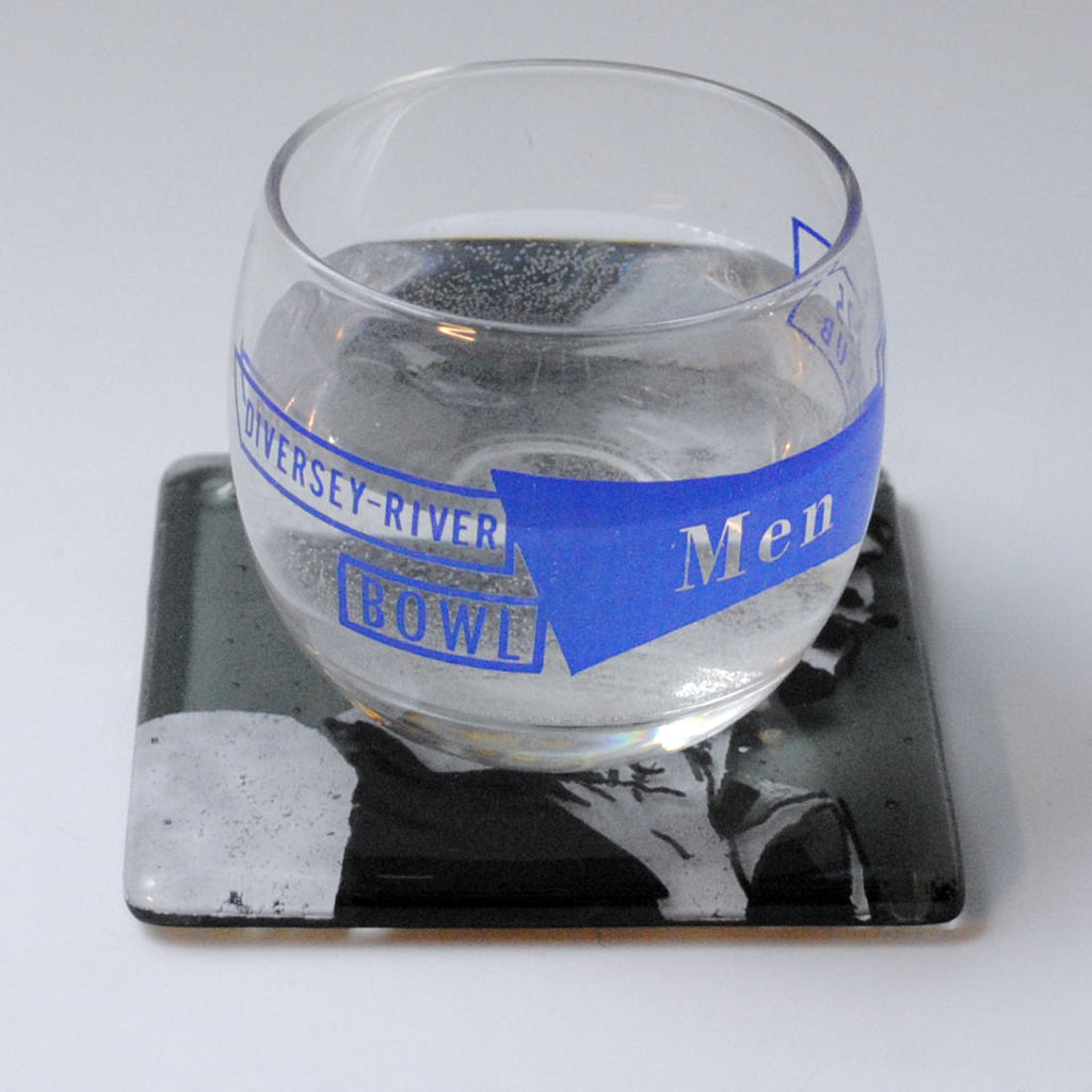 a glass of water sitting on top of a coaster