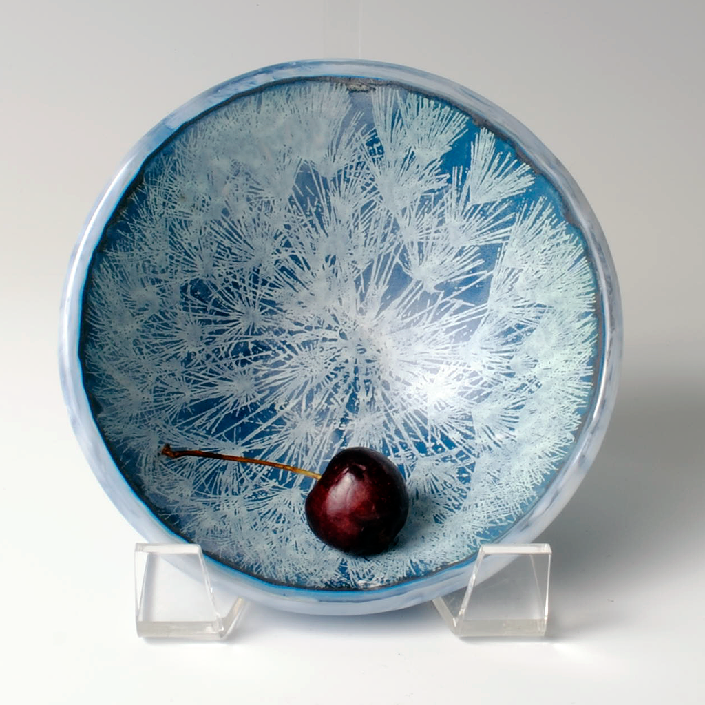 a blue and white bowl with a cherry on it