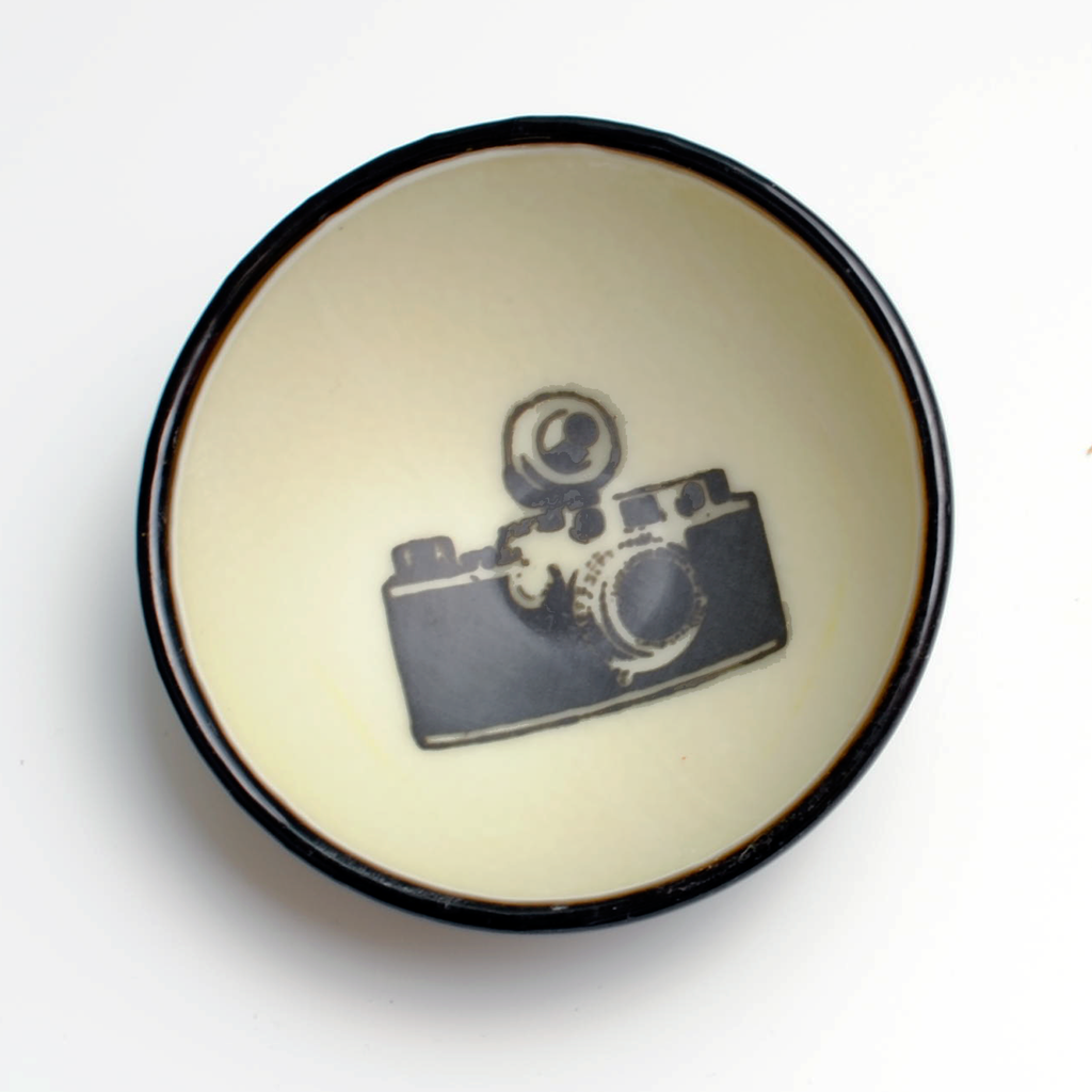 a white and black bowl with a camera on it