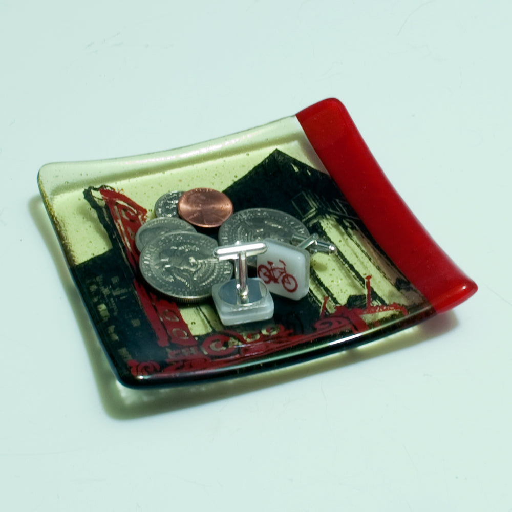 a red and white tray with a couple of coins on it