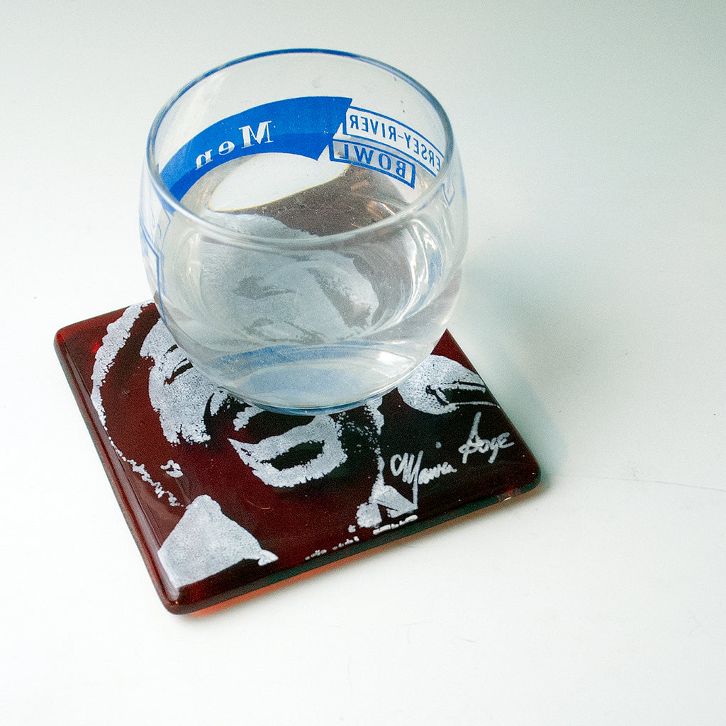 a glass of water sitting on top of a coaster