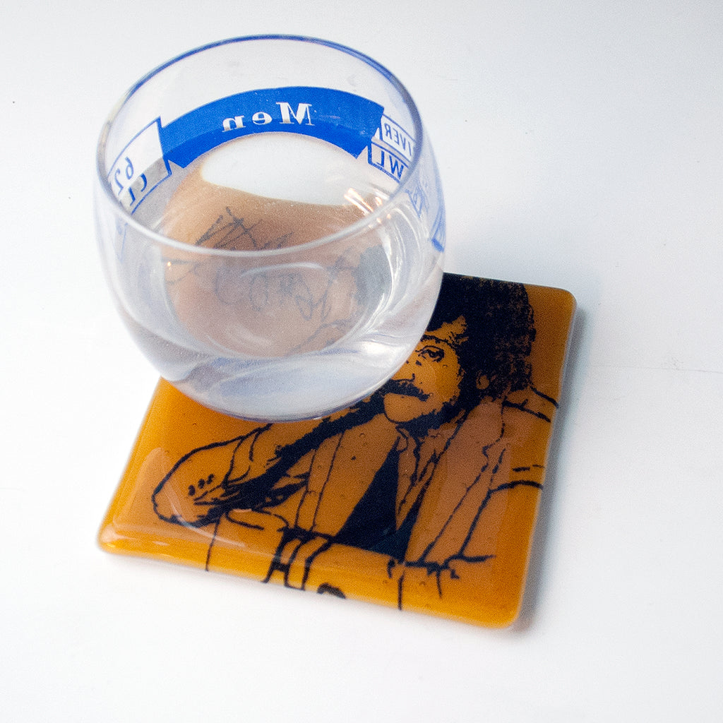 a glass of water sitting on top of a coaster