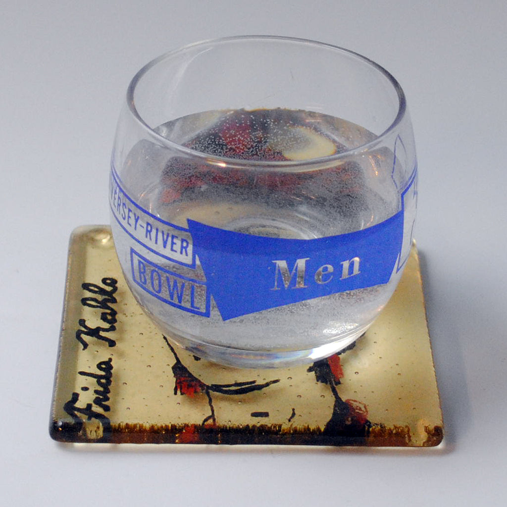 a glass filled with water sitting on top of a coaster