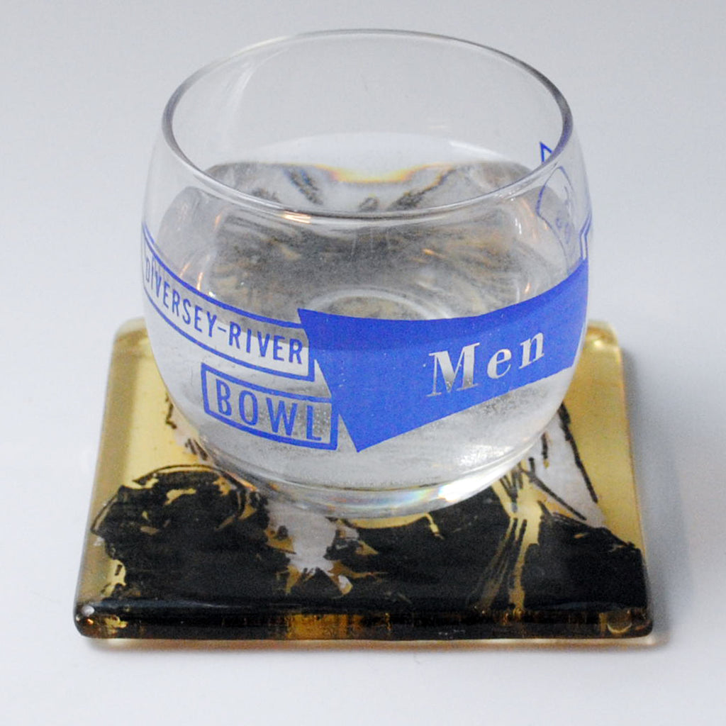 a glass of water sitting on top of a coaster