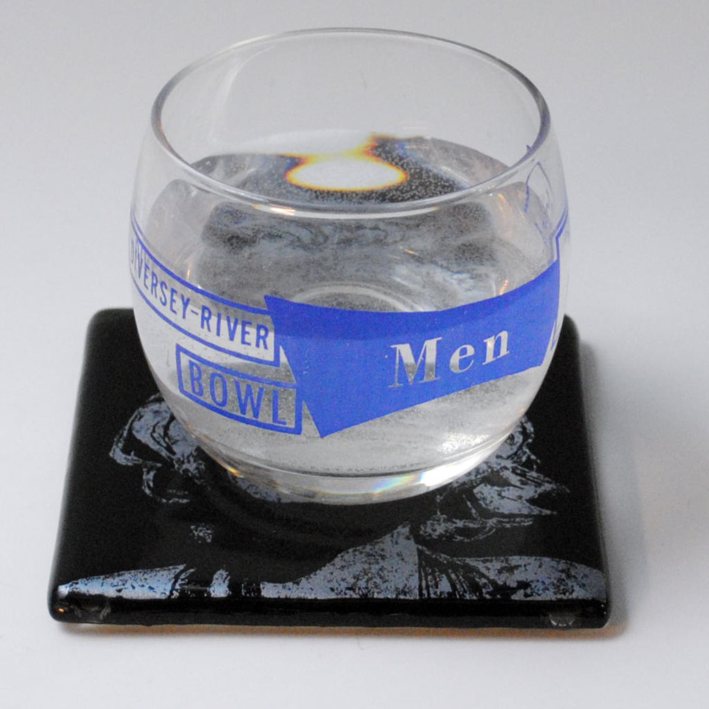 a glass of water sitting on top of a coaster