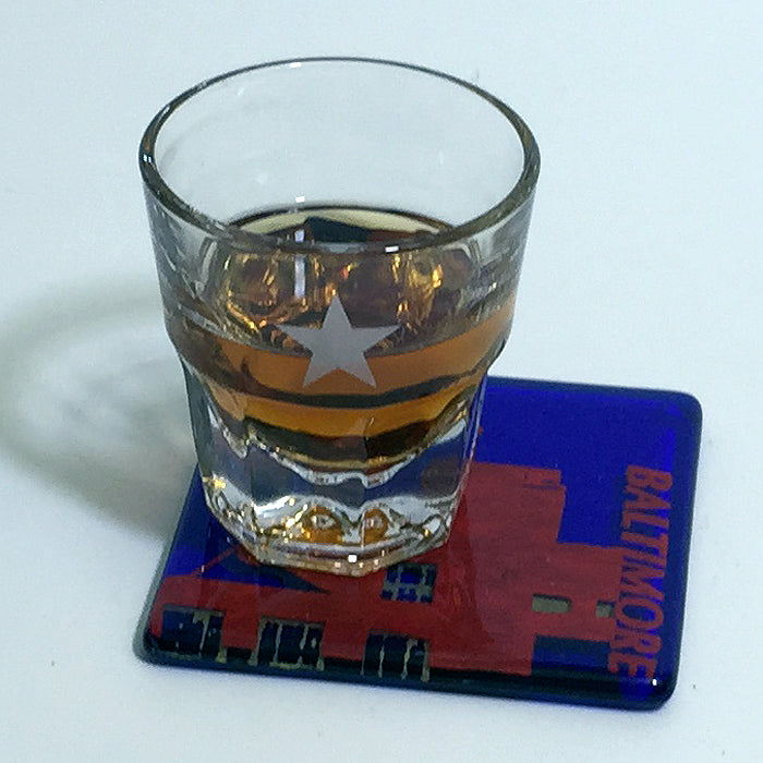 a glass of whiskey sitting on top of a coaster